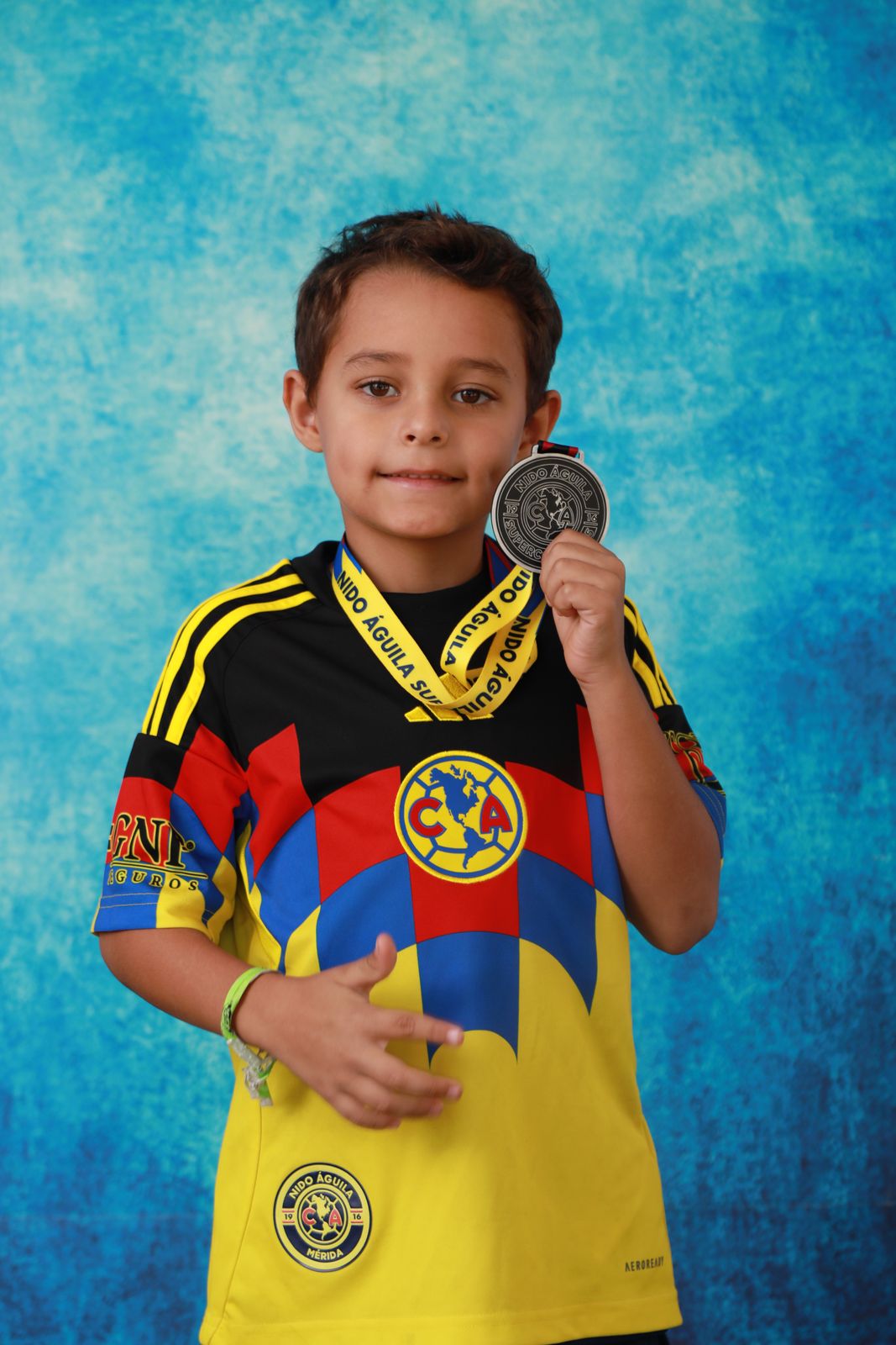 A young player proudly holding up a medal