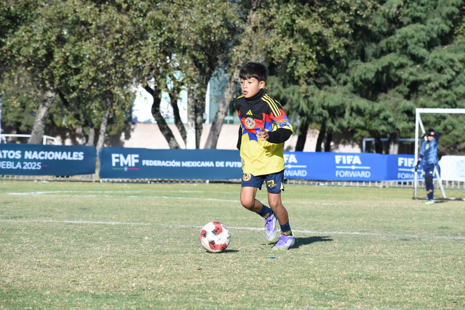 A young player moving onto the ball in open space